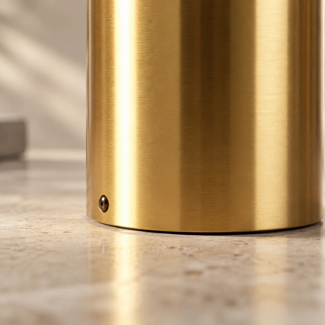 Close low view of the gold cylindrical base and small lower fastener