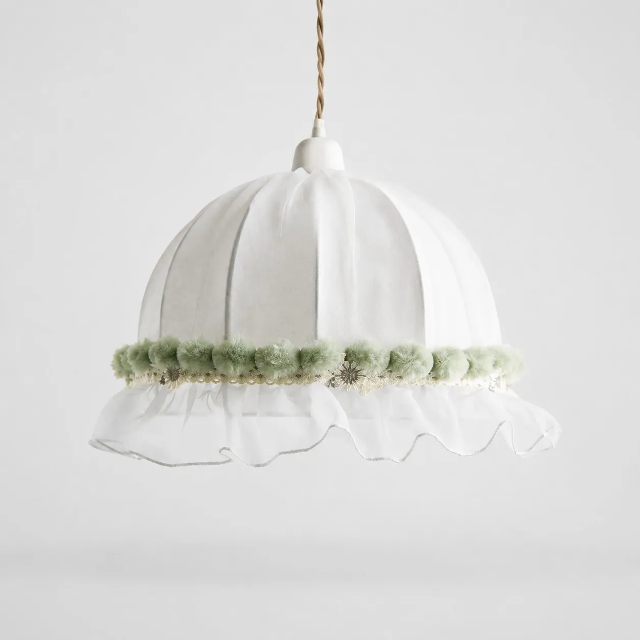 Soft green scalloped lace fabric pendant lamp on a light background